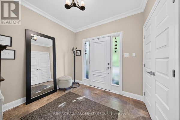 Entryway with a tall black mirror, ottoman, rug, coat rack, and a white front door. - 288 Selby Avenue, Ottawa