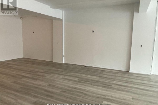 Empty interior commercial space with white walls and light wood-look laminate flooring. - 2880b Kingston Road, Toronto