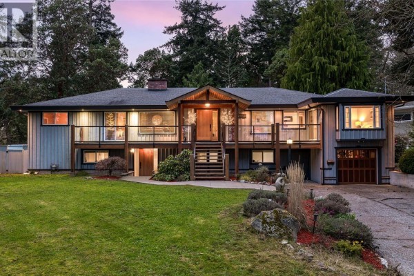 Close-up of the entrance with stairs, stone sculpture, and garden beds - 2881 Phyllis St, Saanich