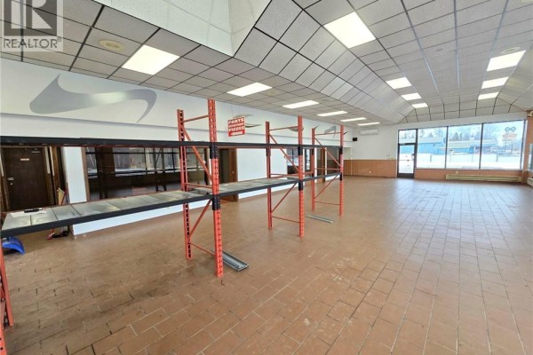 Entrance view with red gate and snow-covered area - 2886 Miramichi Avenue, Bathurst