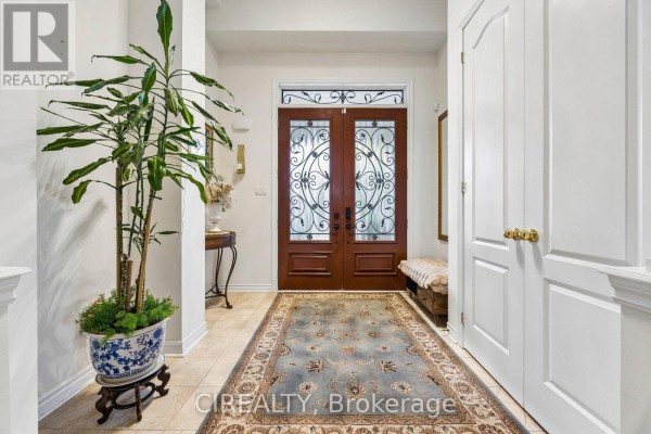 Foyer with tile flooring, a patterned rug, a plant, and double glass doors. - 289 Chatfield Drive, Vaughan