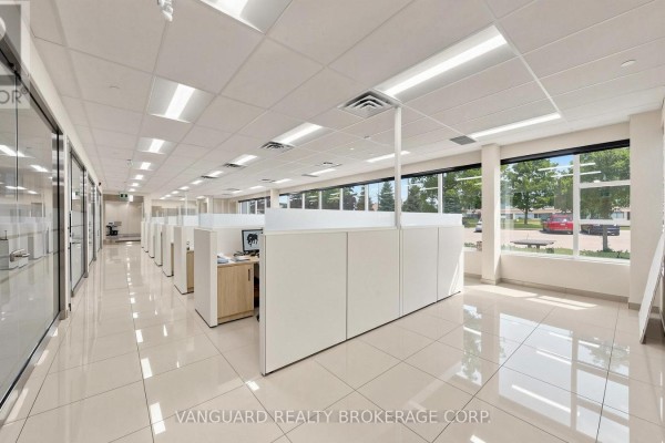 Office space with rows of cubicles, glass partitions, and large windows. - 2891 Langstaff Road, Vaughan