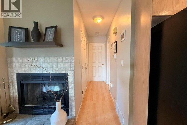 Staircase with wood treads and carpet runner, leading downstairs, with a round mirror. - 28a Wolf Crescent, Invermere