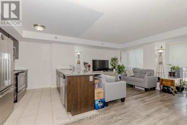Living room with grey sofas, large windows with blinds, and a view of the city lights. - 29 - 100 Dufay Road, Brampton
