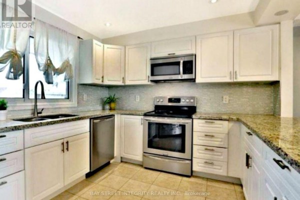 Modern kitchen with white cabinets, stainless steel appliances, and granite countertops. - 29 - 1580 Lancaster Drive, Oakville