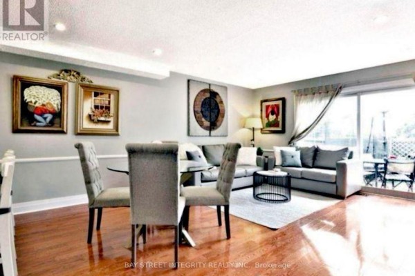 Dining area with a round table and chairs, adjacent to a living room. - 29 - 1580 Lancaster Drive, Oakville