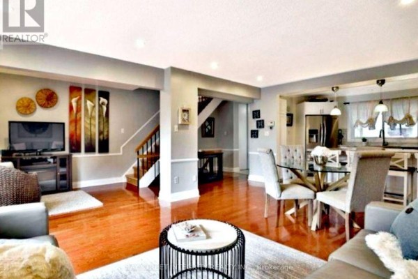 Open concept living space with hardwood floors, connecting dining, living room, and kitchen areas. - 29 - 1580 Lancaster Drive, Oakville