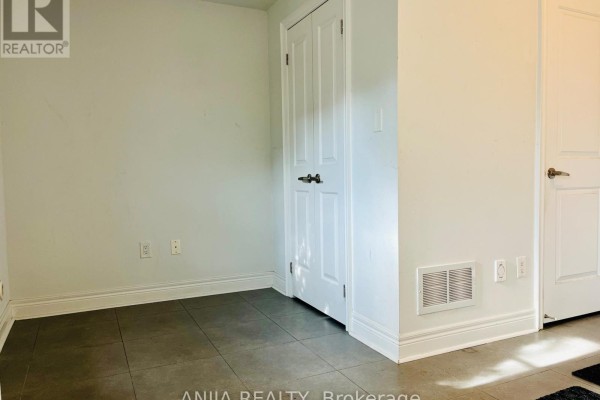 Interior room with gray tiled floor, white walls, and two closed doors. - 29 - 1812 Burnhamthorpe Road E, Mississauga