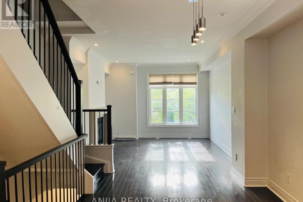 Living room with dark hardwood floors, white walls, large window, and staircase. - 29 - 1812 Burnhamthorpe Road E, Mississauga