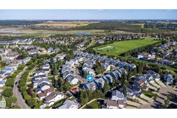 High aerial view of a residential area showing duplexes, houses, and natural landscapes. - #29 200 Erin Ridge Dr, St  Albert