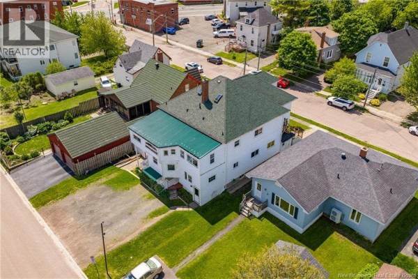 Kitchen featuring wooden cabinets, stainless steel appliances, and a breakfast bar. - 29-31 North Street, Moncton