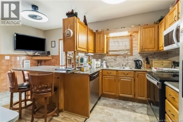 Living room with a ceiling fan, laminate flooring, and large windows. - 29-31 North Street, Moncton