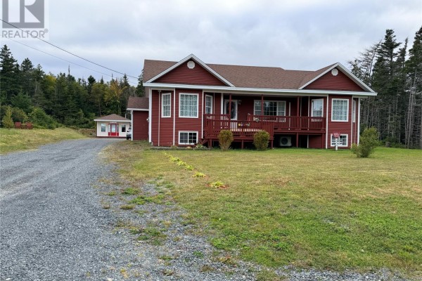A red house with a wraparound deck, surrounded by a lawn, with a gravel driveway and trees. - 29-31 Spracklin's Avenue, Cupids