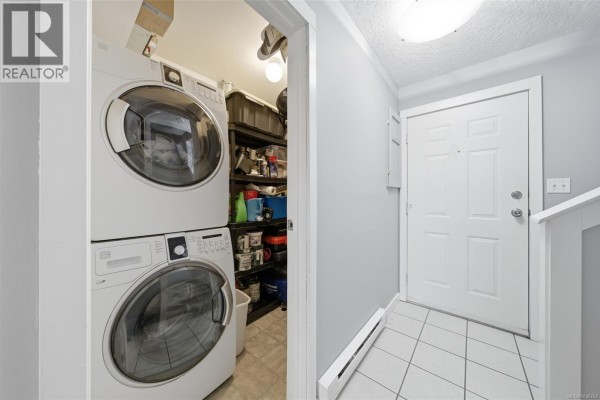 Interior view of a townhouse laundry area with a stacked washer and dryer. - 29 3242 Cowichan Lake Rd, Duncan