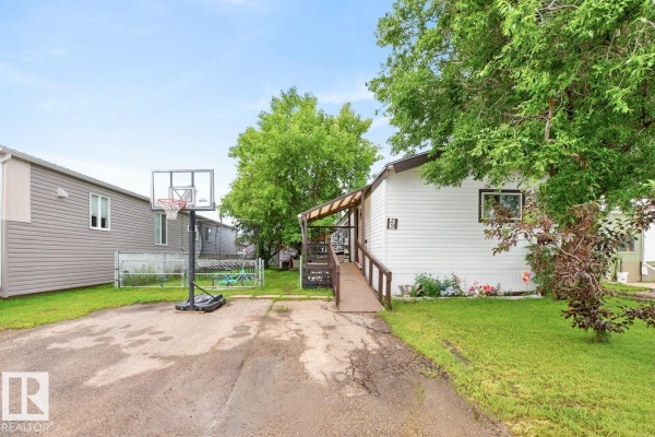 View of a white mobile home with a basketball hoop and adjacent mobile home. - 29 5220 44 Av, Calmar