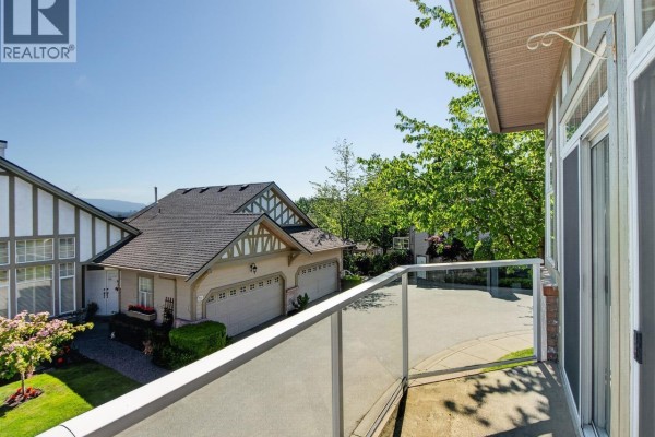 View of townhouses and garages from a balcony with glass railing. - 29 5221 Oakmount Crescent, Burnaby