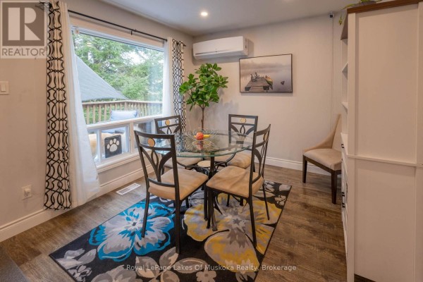 Dining area with a glass-top table, four metal chairs, a floral rug, and large windows. - 29 Amylee Drive, Perry