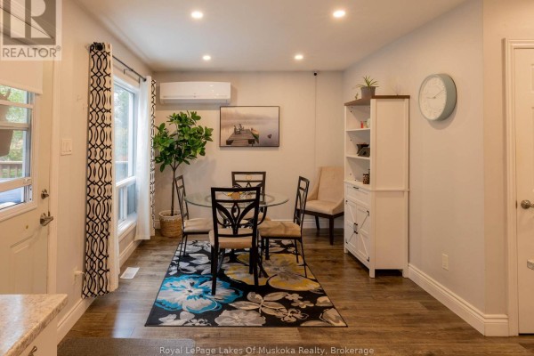 Dining room showing a glass-top table, four chairs, a colorful rug, built-in shelving, and a window view. - 29 Amylee Drive, Perry