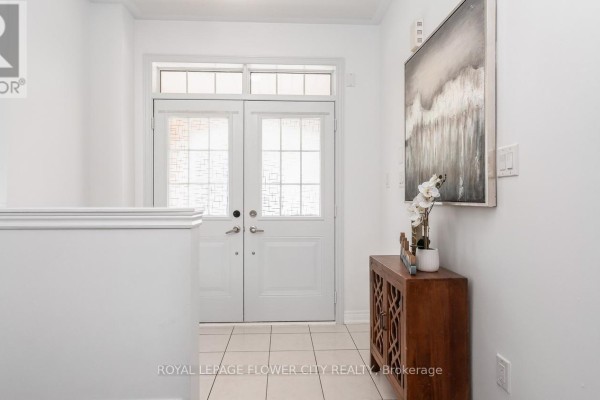 A living room with a tufted sofa, glass coffee table, and two lamps. - 29 Backwater Trail, Brampton