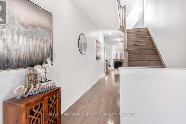 A bathroom with a white vanity, toilet, and a glass-enclosed shower stall. - 29 Backwater Trail, Brampton