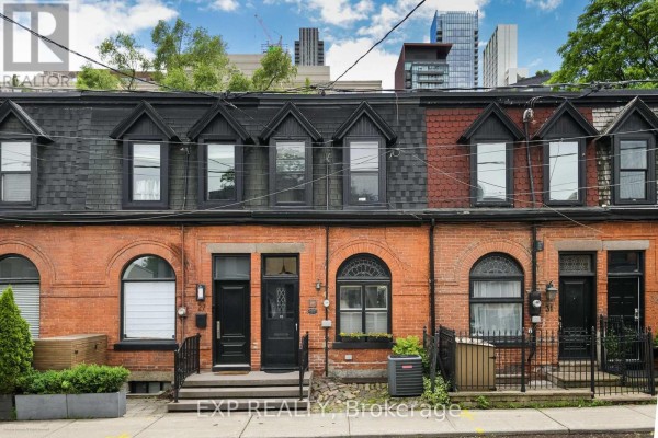 Exterior view of a row of brick townhouses with black pitched roofs and dormer windows. - 29 Belmont Street, Toronto
