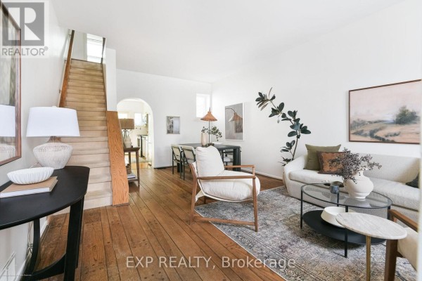 Open-concept living and dining area with hardwood floors, a staircase, sofa, chairs, and dining table. - 29 Belmont Street, Toronto