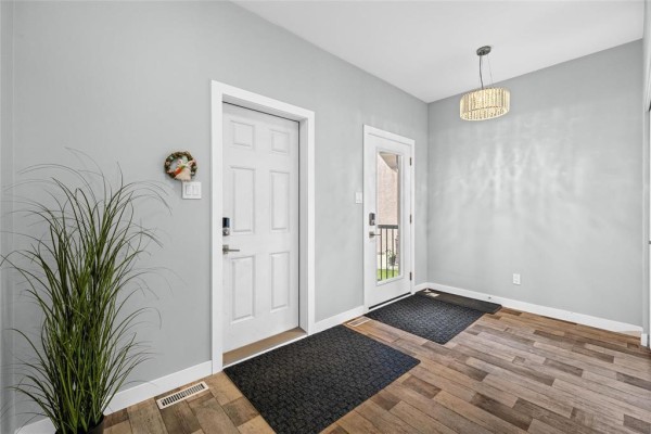 Interior foyer with light blue walls, white doors, and wood-look flooring. - 29 Cartmill Bay, West St Paul
