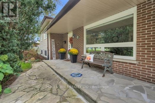 Stone walkway leading to the covered front entrance of the home with a bench. - 29 Johnston Street, Georgina