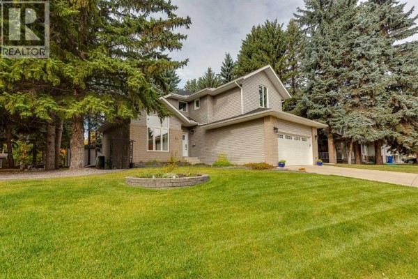 Front exterior of a two-story house with grey siding and brick accents. - 29 Pickwick Lane, Lacombe