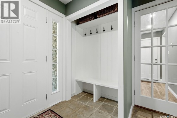 Interior entryway with white bench, coat hooks, and a wooden hall tree. - 29 Ridgedale Bay, White City
