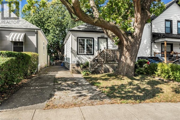 Side view of the house showing gravel driveway and landscaping. - 29 Wexford Avenue N, Hamilton