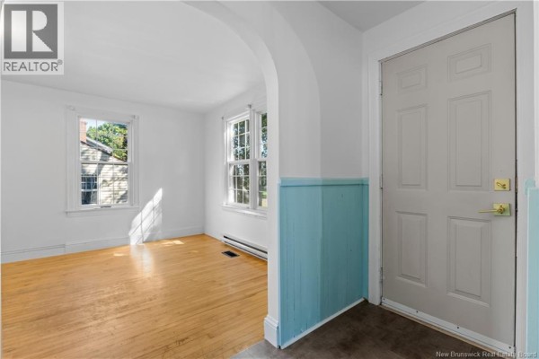 Interior entryway with white walls, light wood floors, and a blue wainscoting accent wall. - 29 Wilmot Avenue, Riverview