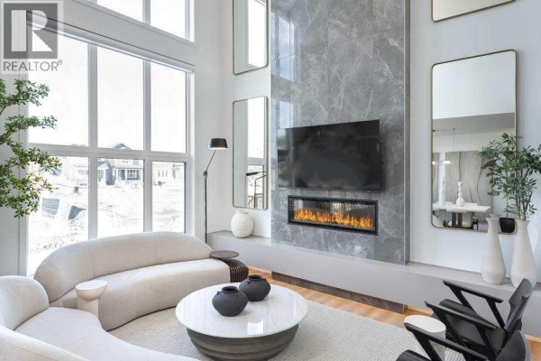 Living room fireplace, large windows with view of houses, and modern sofa. - 29 Wolf Hollow Common Se, Calgary