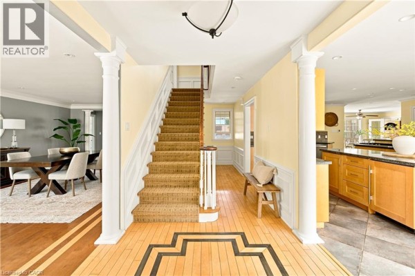 Interior foyer with a staircase, wooden floors, and doorways to adjacent rooms. - 290 Bridgeport Road E, Waterloo