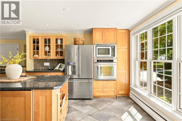 Kitchen with light wood cabinets, stainless steel appliances, and a large window. - 290 Bridgeport Road E, Waterloo