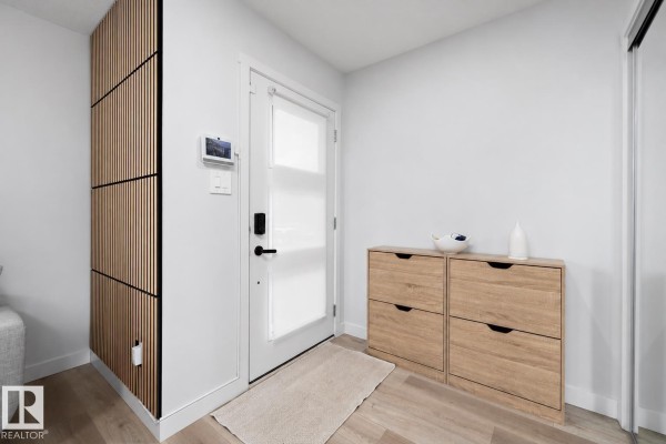 Entryway with white walls, light wood flooring, a frosted glass door, and wooden shoe cabinets. - 290 Jensen Lakes Bv, St  Albert