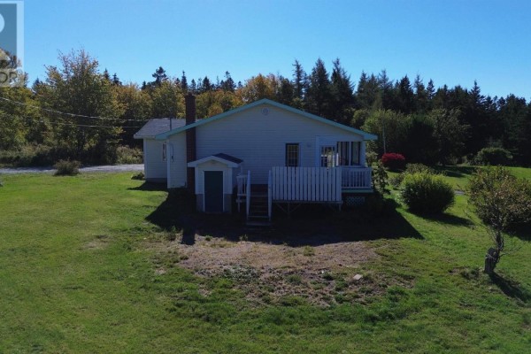 Rear exterior of a white house showing a small shed with a green door and a deck. - 290 Macvicar Road, Enon