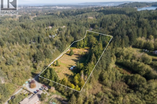 Aerial view of a cleared lot outlined in white, surrounded by trees. - 2900 Amrik Rd, Nanaimo