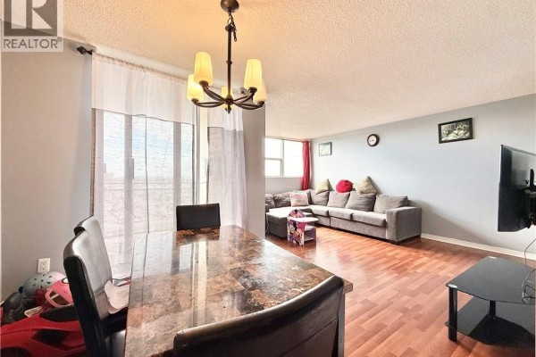 Dining area and living room with sectional sofa and dining table. - 2900 Battleford Road Unit# 1013, Mississauga