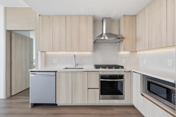 Close-up of a modern kitchen with light wood cabinets, white countertops, and stainless steel appliances. - 2908 10750 135a Street, Surrey