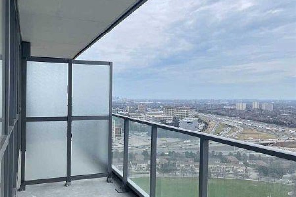 Balcony with glass railing overlooking a cityscape and a park on an overcast day. - 2909 - 32 Forest Manor Street, Toronto