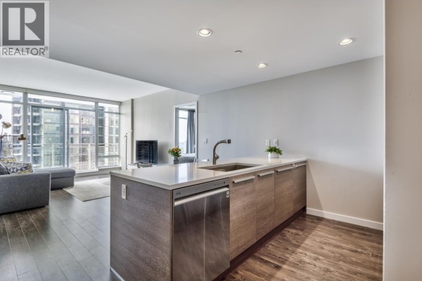 Modern kitchen with white and grey cabinetry, stainless steel appliances, and a gas stovetop. - 2909 4485 Skyline Drive, Burnaby