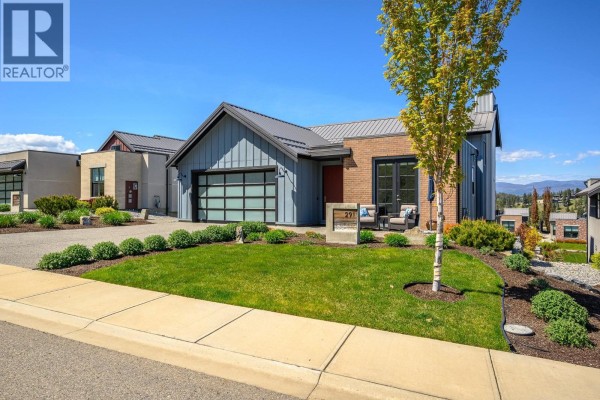 Exterior view of the modern home and driveway with a tree in the foreground. - 291 Grange Drive, Vernon