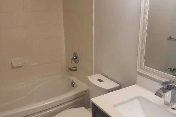 Bathroom with a white bathtub, toilet, and vanity with a white countertop. - 2911 - 81 Navy Wharf Court, Toronto