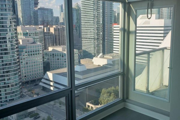 Balcony with glass railing overlooking a cityscape with tall buildings and streets below. - 2911 - 81 Navy Wharf Court, Toronto