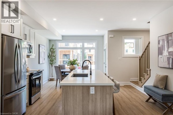 Wide view of the kitchen, island, dining area, and living room. - 292 Vine Street Unit# 82, St  Catharines