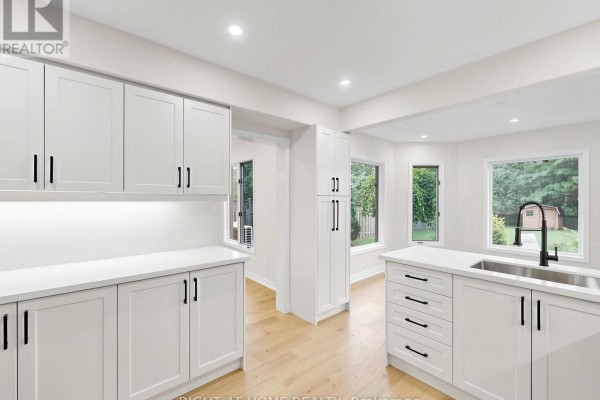 Modern kitchen with white cabinets, quartz counters, and hardwood floors - 2920 Kingsway Drive Oakville