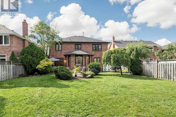 Expansive backyard with lush green grass, mature trees, and a privacy fence. - 2920 Kingsway Drive, Oakville