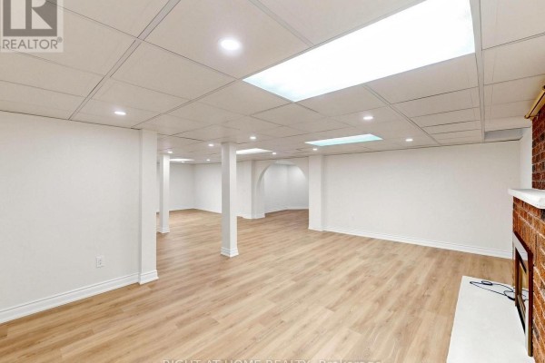 Finished basement with recessed lighting, skylights, wood-look floors, and fireplace - 2920 Kingsway Drive Oakville