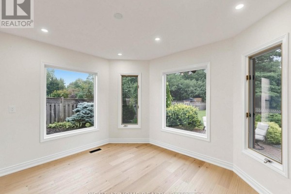 Living room with hardwood floors and large windows overlooking backyard - 2920 Kingsway Drive Oakville